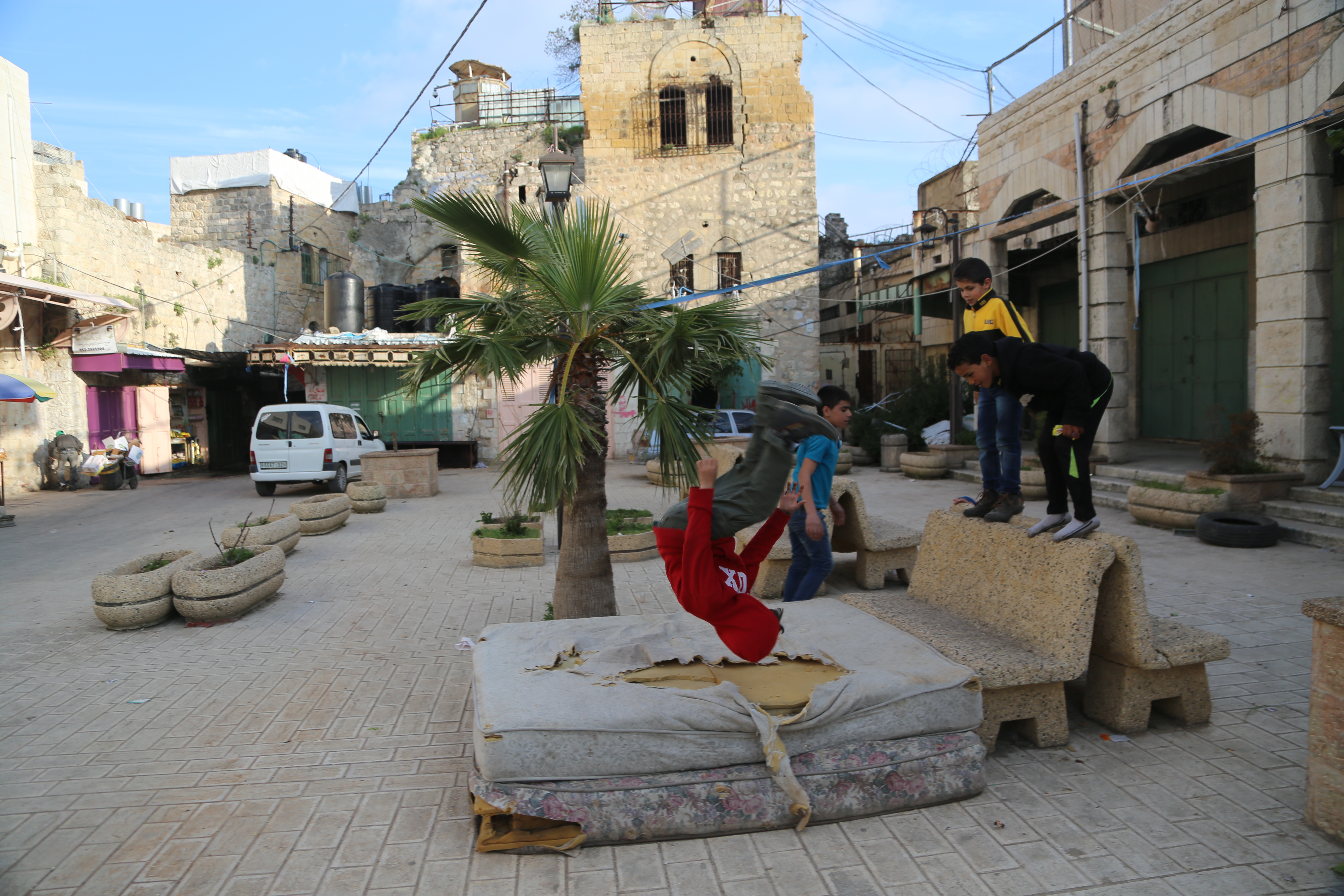 Palestinian kids play in Hebron feet away from Israeli settlements and the gated-up Shuhada Street, the former commercial hub of the city that was closed after the 1994 Ibrahimi Mosque massacre.