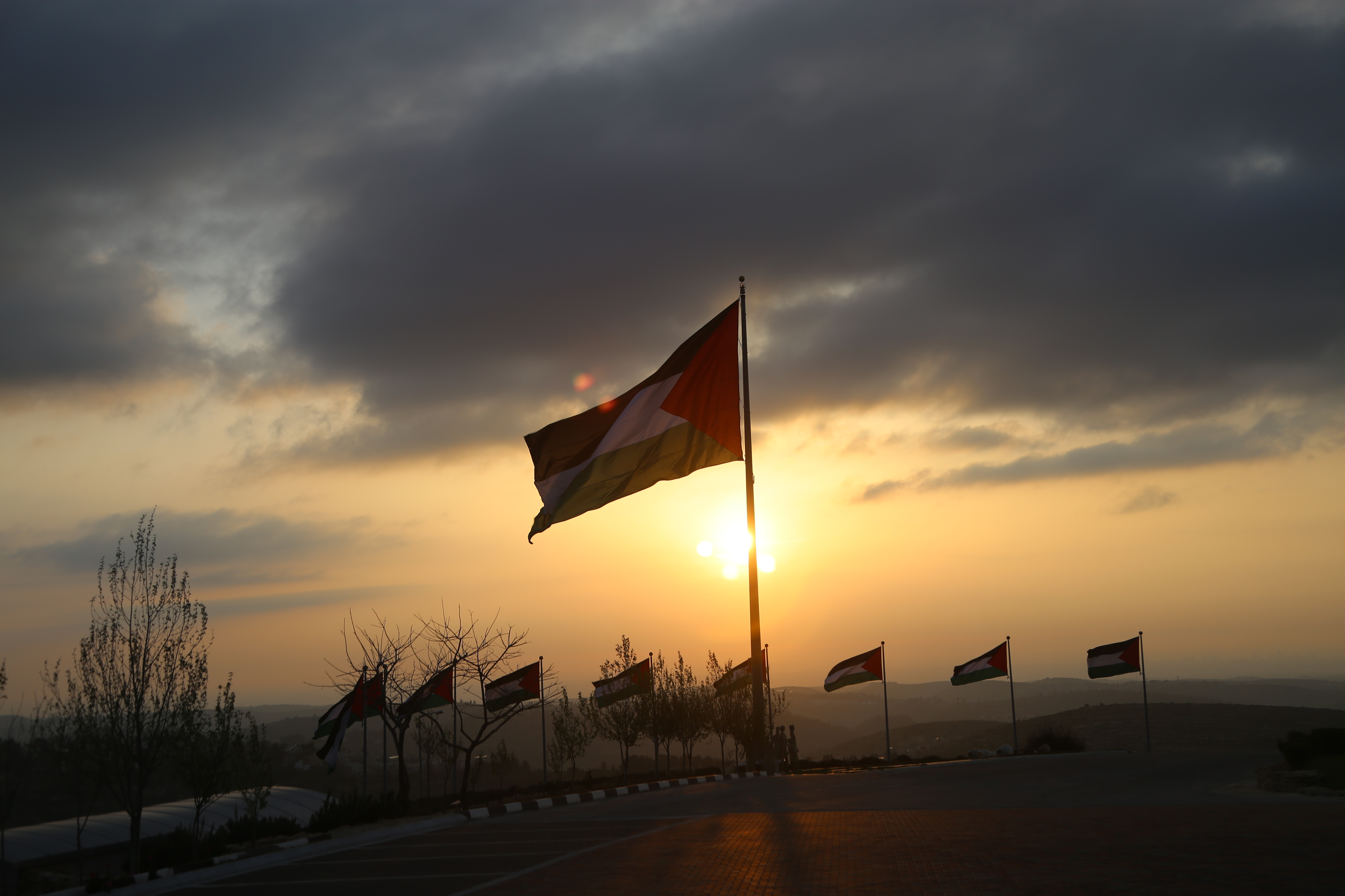 A Palestinian flag flies against the sunset on the top of the hill in Rawabi.